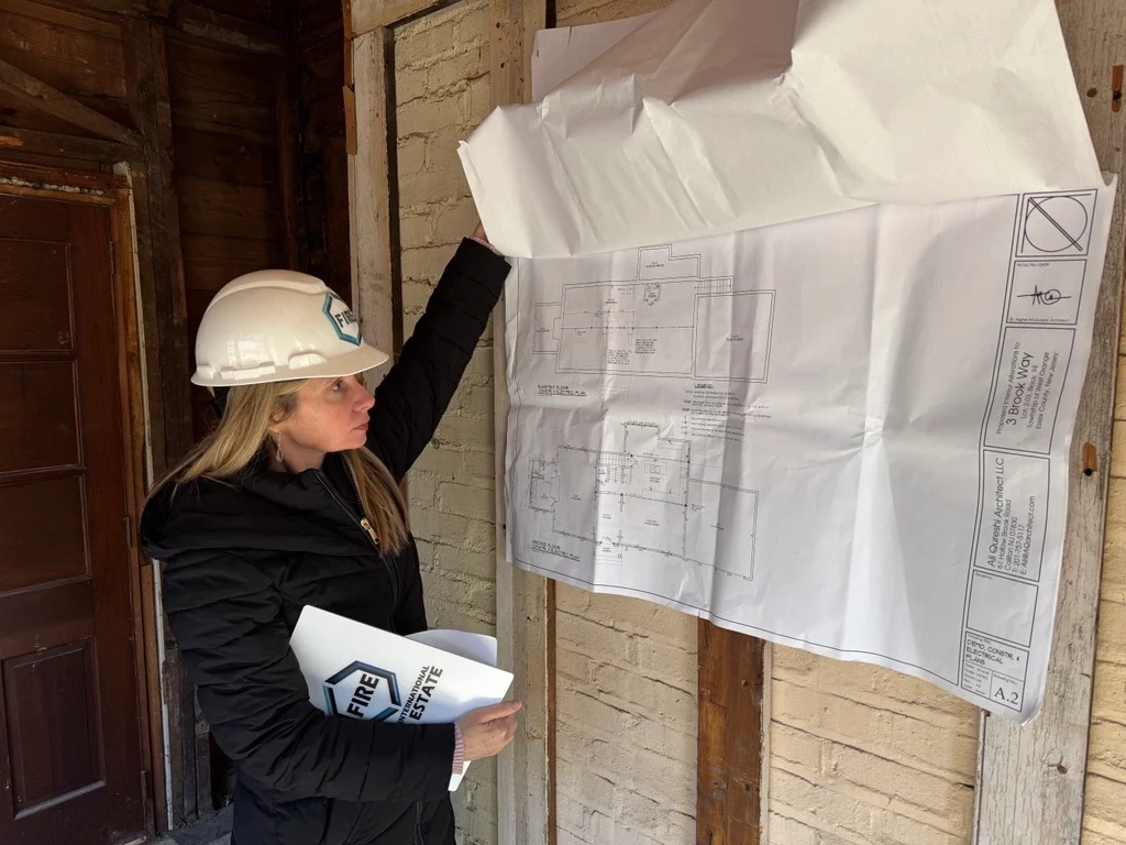 Mary Fourte reviewing the 3 Brook Way drawings in a FIRE hard hat