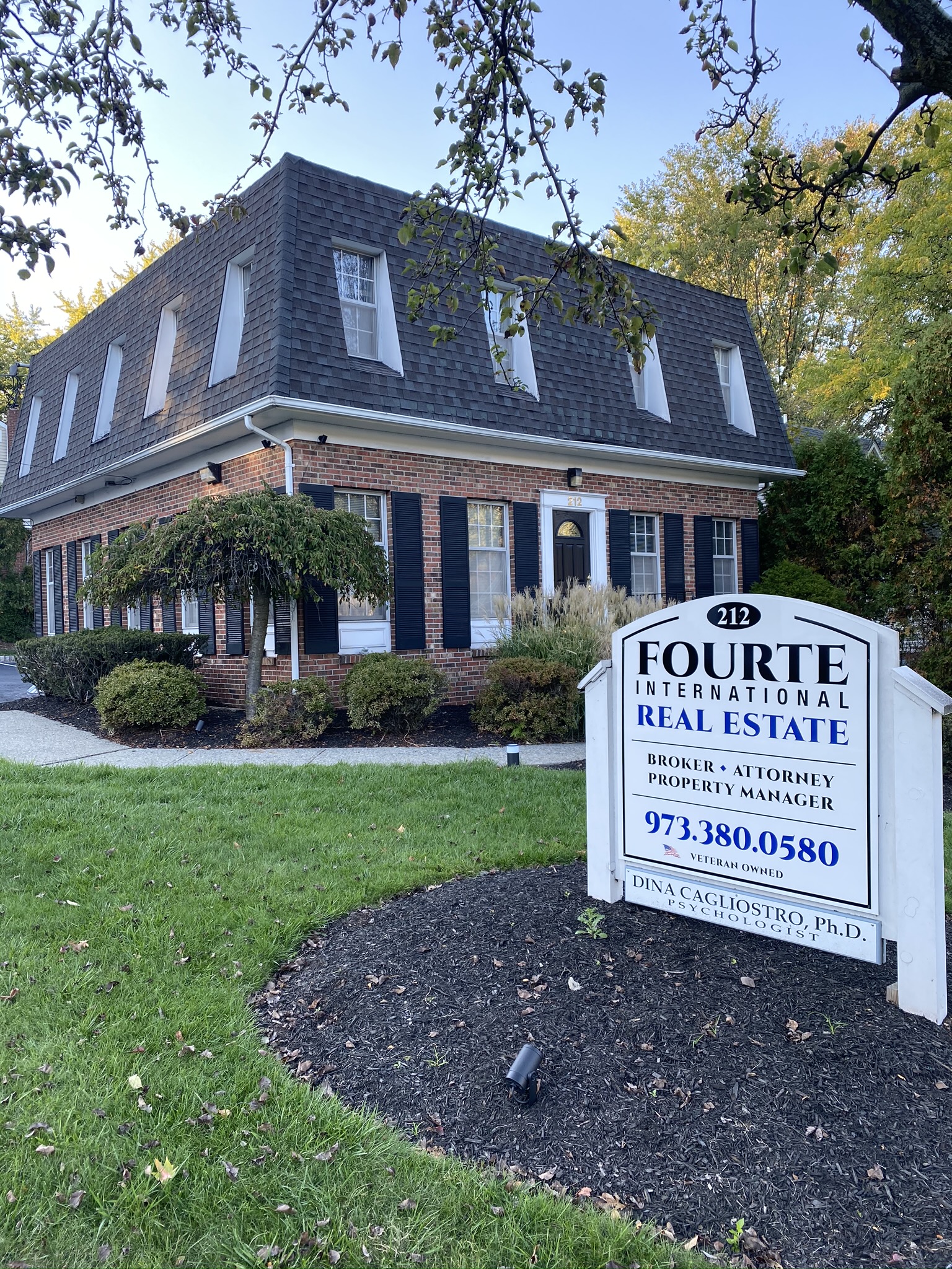 IMG_1891 Fourte International Real Estate's Headquarters building in Essex County New Jersey with a sign on the front lawn advertising broker, attorney and property manager services